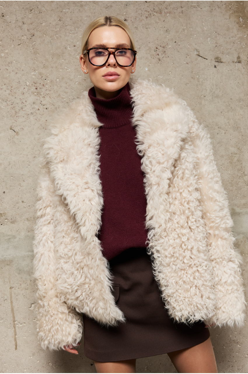 Short reversible sheepskin jacket made of natural sheepskin in light beige color